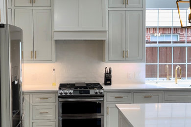 Example of a mid-sized minimalist l-shaped eat-in kitchen design in Dallas with shaker cabinets, white cabinets, quartz countertops, white backsplash, subway tile backsplash, an island and white countertops
