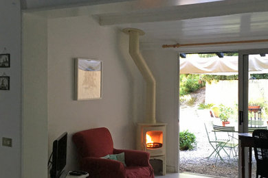 Idee per un piccolo soggiorno country chiuso con stufa a legna, pavimento bianco, soffitto a cassettoni e pareti in mattoni