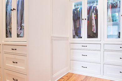 Design ideas for a mid-sized beach style gender-neutral walk-in wardrobe in Other with flat-panel cabinets, white cabinets and medium hardwood floors.