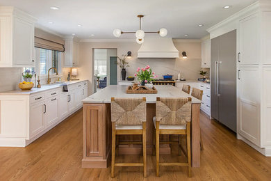 Large transitional l-shaped medium tone wood floor and brown floor eat-in kitchen photo in Detroit with recessed-panel cabinets, white cabinets, quartzite countertops, multicolored backsplash, stone slab backsplash, an island and white countertops
