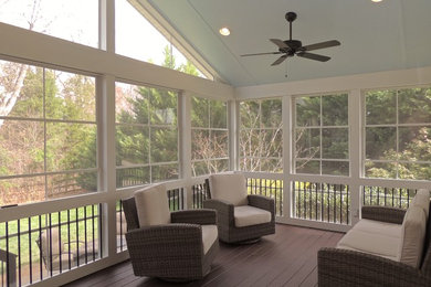 This is an example of a mid-sized traditional screened-in back porch design in Charlotte with decking and a roof extension.