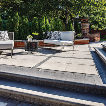 Traditional poolside paradise with grey and black pavers