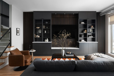 Living room - large industrial open concept medium tone wood floor and brown floor living room idea in Chicago with white walls and a media wall