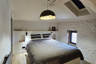 Diseño de dormitorio tipo loft y blanco y madera contemporáneo de tamaño medio con paredes blancas, suelo laminado y vigas vistas