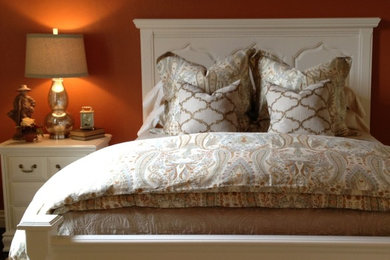 Inspiration for a mid-sized timeless guest medium tone wood floor and brown floor bedroom remodel in Oklahoma City with orange walls