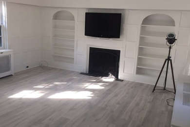 На фото: открытая гостиная комната среднего размера в современном стиле с белыми стенами, стандартным камином и телевизором на стене с