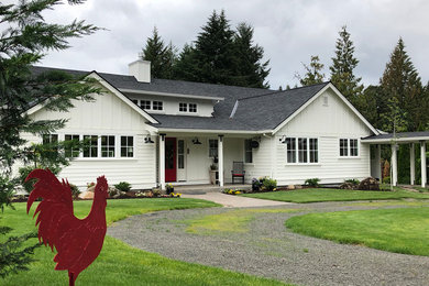 Example of a mid-sized cottage white one-story wood exterior home design in Portland with a shingle roof