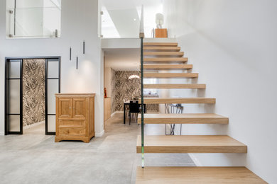 Idée de décoration pour un escalier droit minimaliste de taille moyenne avec des marches en bois, des contremarches en bois et un garde-corps en verre.
