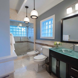 Idee per una stanza da bagno padronale stile marinaro di medie dimensioni con lavabo integrato, ante lisce, ante nere, top in vetro, doccia alcova, WC a due pezzi, piastrelle beige, piastrelle in pietra, pareti grigie e pavimento in marmo