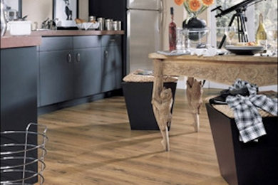 Small minimalist medium tone wood floor and brown floor open concept kitchen photo in New York with flat-panel cabinets, black cabinets, wood countertops, stainless steel appliances, an island and brown countertops