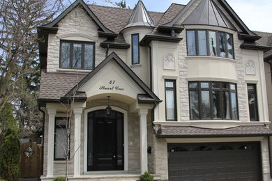 Mid-sized traditional two-storey beige house exterior in Toronto with mixed siding.