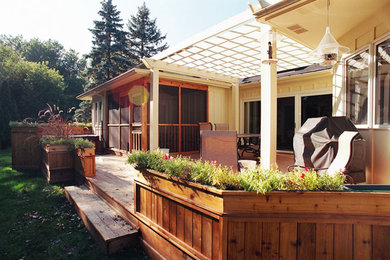 Inspiration for a mid-sized timeless backyard deck container garden remodel in Minneapolis with a pergola