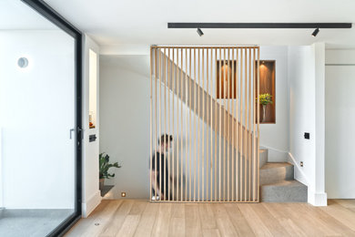 Photo of a contemporary curved wood railing staircase in London with limestone treads and limestone risers.