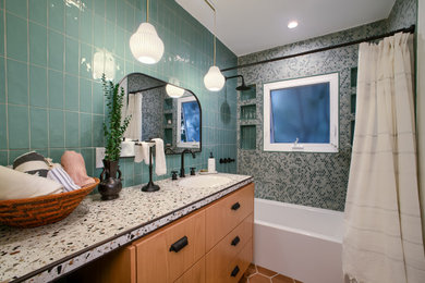 ロサンゼルスにあるエクレクティックスタイルのおしゃれな浴室 (シャワー付き浴槽	、緑のタイル、サブウェイタイル、アンダーカウンター洗面器、テラゾーの洗面台、マルチカラーの洗面カウンター、洗面台1つ) の写真