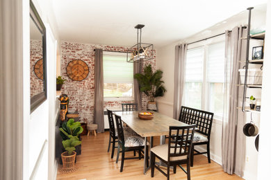 Inspiration for a mid-sized industrial medium tone wood floor, orange floor and brick wall kitchen/dining room combo remodel in Philadelphia with white walls