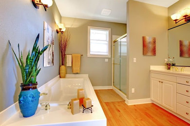 Bathroom - mid-sized tropical brown floor and medium tone wood floor bathroom idea in Miami with raised-panel cabinets, white cabinets, beige walls and an undermount sink