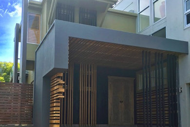 Photo of a mid-sized contemporary front door in Townsville with grey walls, porcelain floors, a double front door, a medium wood front door and grey floor.