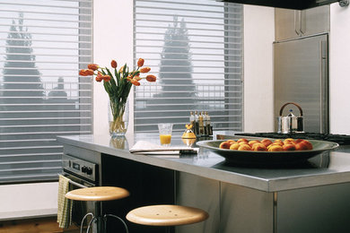 Inspiration for a mid-sized modern l-shaped concrete floor and brown floor enclosed kitchen remodel in Denver with stainless steel appliances, an undermount sink, flat-panel cabinets, gray cabinets, stainless steel countertops and an island