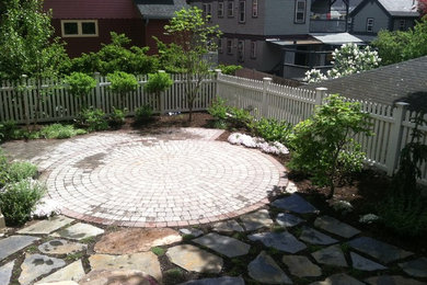 Photo of a mid-sized contemporary partial sun backyard stone retaining wall landscape in Boston.