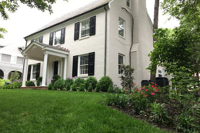 Mid-sized elegant white two-story brick exterior home photo in Other with a shingle roof