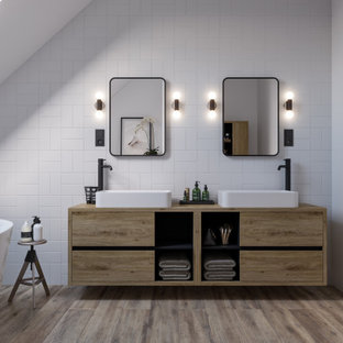 Modern inredning av ett mellanstort brun brunt badrum för barn, med släta luckor, bruna skåp, ett fristående badkar, en vägghängd toalettstol, vit kakel, keramikplattor, vita väggar, klinkergolv i keramik, ett konsol handfat, laminatbänkskiva och brunt golv