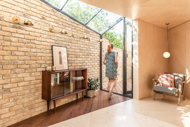 Photo of a small scandinavian home studio in London with beige walls, a freestanding desk and beige floors.