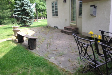 Ejemplo de patio tradicional sin cubierta en patio trasero con adoquines de hormigón