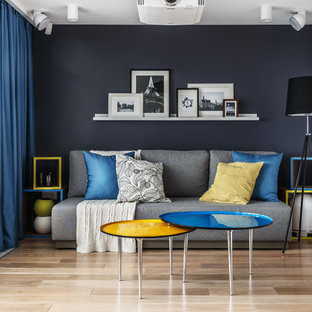 Bild på ett funkis separat vardagsrum, med blå väggar, mellanmörkt trägolv och brunt golv