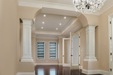 Example of a large minimalist formal and open concept dark wood floor and brown floor living room design in Vancouver with beige walls, a standard fireplace and a wood fireplace surround