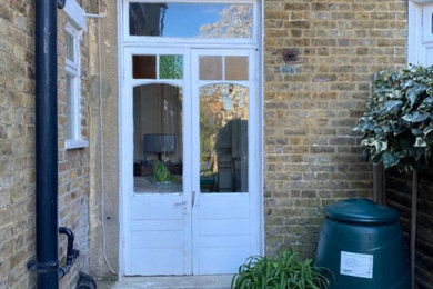 This is an example of a medium sized classic front door in London with a double front door and a white front door.