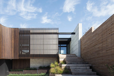 This is an example of a large contemporary two-storey house exterior in Melbourne with wood siding and a flat roof.