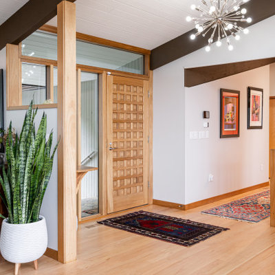 Inspiration for a mid-sized mid-century modern light wood floor, beige floor and exposed beam entryway remodel in Other with gray walls and a light wood front door