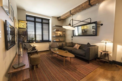 Example of a mid-sized transitional formal and open concept medium tone wood floor and brown floor living room design in New York with beige walls, no fireplace and no tv