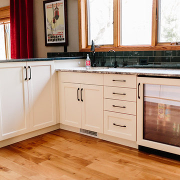 Two Leveled Bar with Off White Cabinets off Kitchen