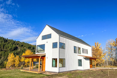 Inspiration for a mid-sized farmhouse white two-story metal and shingle exterior home remodel in Other with a shingle roof and a black roof