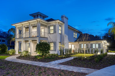 Example of a large beach style two-story stucco house exterior design in Tampa with a tile roof