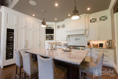 Open concept kitchen - large transitional l-shaped dark wood floor and brown floor open concept kitchen idea in Atlanta with an undermount sink, beaded inset cabinets, white cabinets, quartz countertops, white backsplash, subway tile backsplash, paneled appliances and an island