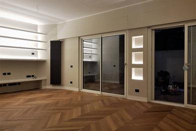 Modelo de salón contemporáneo de tamaño medio con paredes beige, suelo de madera clara y televisor colgado en la pared