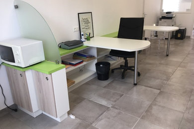 Exemple d'un grand bureau tendance avec un mur blanc, un sol en carrelage de céramique, aucune cheminée, un bureau intégré et un sol gris.