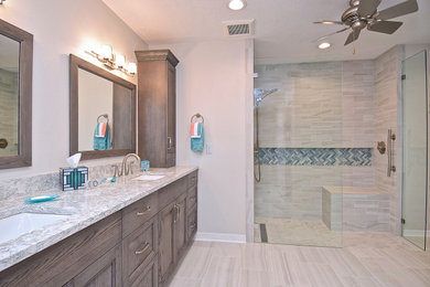 Mid-sized transitional master beige tile and porcelain tile porcelain tile, beige floor and double-sink bathroom photo in Tampa with raised-panel cabinets, medium tone wood cabinets, a two-piece toilet, beige walls, an undermount sink, quartz countertops, a hinged shower door, white countertops and a built-in vanity