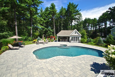 Photo of a large traditional custom-shaped pool in Boston with concrete pavers and a hot tub.