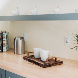 Cette photo montre une arrière-cuisine linéaire moderne de taille moyenne avec un évier encastré, un placard à porte shaker, des portes de placard grises, un plan de travail en quartz, une crédence jaune, une crédence en carreau de porcelaine, un électroménager encastrable, un sol en bois clair, un îlot central, un sol beige et un plan de travail gris.