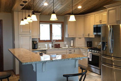 Example of a mid-sized transitional u-shaped porcelain tile and gray floor enclosed kitchen design in Denver with an undermount sink, raised-panel cabinets, white cabinets, granite countertops, stainless steel appliances and a peninsula
