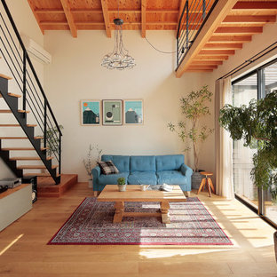 他の地域のアジアンスタイルのおしゃれなLDK (白い壁、淡色無垢フローリング、薪ストーブ、ベージュの床) の写真