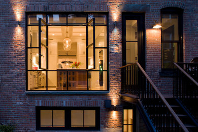 Transitional three-story brick exterior home idea in New York