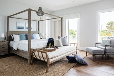 タンパにあるビーチスタイルのおしゃれな寝室 (グレーの壁、無垢フローリング、茶色い床) のインテリア