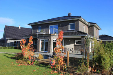Großes, Einstöckiges Stilmix Einfamilienhaus mit gestrichenen Ziegeln, schwarzer Fassadenfarbe, Walmdach, Ziegeldach, schwarzem Dach und Verschalung in Hannover