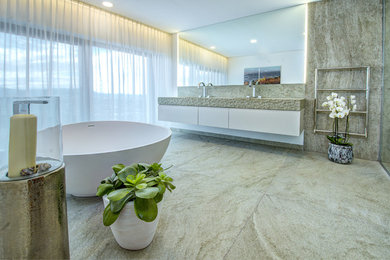 ミュンヘンにある中くらいなコンテンポラリースタイルのおしゃれなマスターバスルーム (置き型浴槽、緑のタイル、石スラブタイル、横長型シンク、珪岩の洗面台、緑の床) の写真