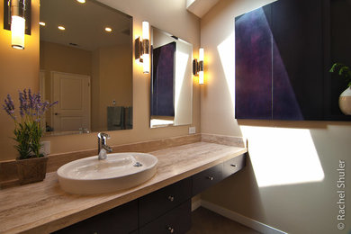 Bathroom - large modern master beige tile ceramic tile and brown floor bathroom idea in San Francisco with flat-panel cabinets, dark wood cabinets, a one-piece toilet, beige walls, a vessel sink, limestone countertops, a hinged shower door and beige countertops