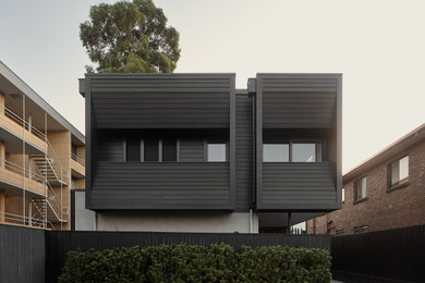 Design ideas for a mid-sized modern black house exterior in Brisbane with four or more storeys and concrete fiberboard siding.